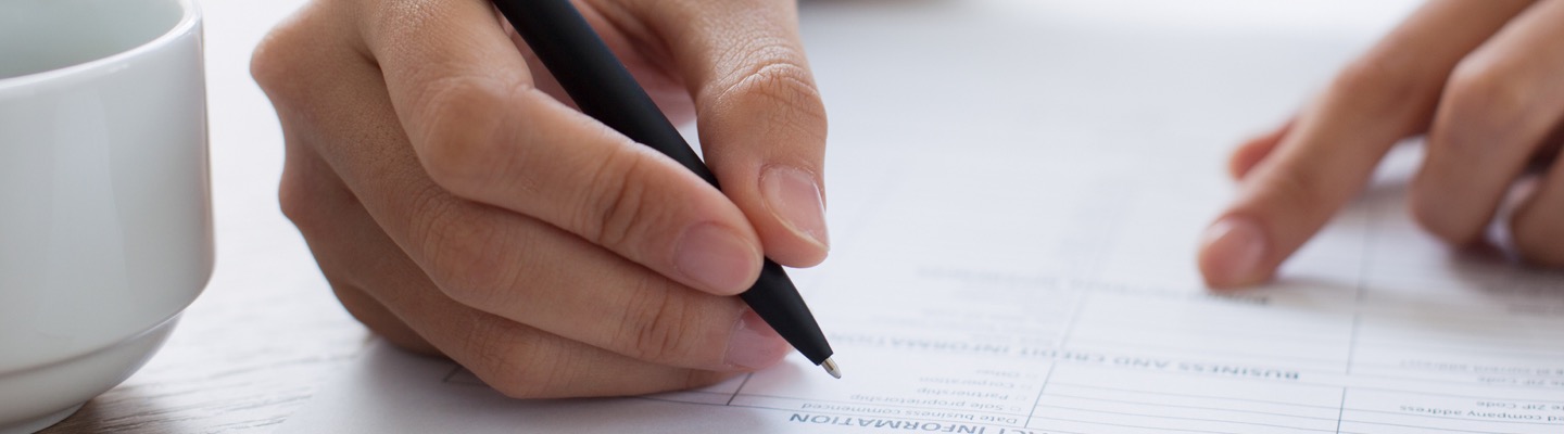 Close up of a person signing form